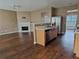 Open-concept living space with a cozy fireplace, hardwood floors, and kitchen access at 3615 Hutchinson Trace Dr, Cumming, GA 30040