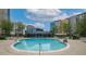 Community pool surrounded by lounge chairs, umbrellas, and modern buildings at 44 Peachtree Nw Pl # 629, Atlanta, GA 30309