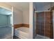 Bathroom featuring a soaking tub, tiled shower, and wood-look flooring at 5660 Sable Bay Pt, Atlanta, GA 30349