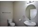 Powder room features a pedestal sink, oval mirror, and neutral wall color at 5660 Sable Bay Pt, Atlanta, GA 30349