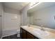 This bathroom has a double sink vanity, framed mirror, a shower-tub combo, and dark LVP floors at 5660 Sable Bay Pt, Atlanta, GA 30349