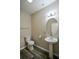Powder room features a pedestal sink, oval mirror, and neutral wall color and laminate flooring at 5660 Sable Bay Pt, Atlanta, GA 30349
