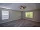 Spacious bedroom with carpeted floors, two windows, and a ceiling fan at 5660 Sable Bay Pt, Atlanta, GA 30349