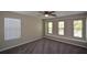 This bedroom has soft carpet, a ceiling fan, and lots of natural light from three windows with blinds at 5660 Sable Bay Pt, Atlanta, GA 30349