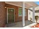 Close up of Front Porch entry with brick, white pillars, and glass-accented front door at 5660 Sable Bay Pt, Atlanta, GA 30349