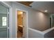 Upstairs hallway with an open bathroom doorway and other rooms at 5660 Sable Bay Pt, Atlanta, GA 30349