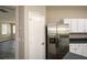 Pantry and stainless steel refrigerator, complemented by white cabinets and a glimpse of the living area at 5660 Sable Bay Pt, Atlanta, GA 30349