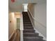 Carpeted stairway with white banister leading to the upper level, brightened by a window at 5660 Sable Bay Pt, Atlanta, GA 30349