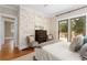 Bedroom with a decorative brick wall, deck access, and neutral tones for a modern aesthetic at 638 Cooledge Ne Ave, Atlanta, GA 30306