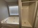 Well-lit bathroom featuring a combination tub/shower with a large garden tub at 120 Grove Ln, Temple, GA 30179