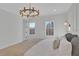 Serene bedroom features a plush bed, two windows offering natural light, and a stylish chandelier, offering a relaxing retreat at 345 Sugarview Rd, Sugar Hill, GA 30518
