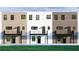 Back view of townhouses with brick facade, personal balconies, and a shared lawn at 345 Sugarview Rd, Sugar Hill, GA 30518