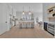 Bright kitchen features a center island with bar seating, modern appliances, and elegant pendant lighting at 345 Sugarview Rd, Sugar Hill, GA 30518