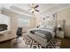 Bedroom with a ceiling fan, tray ceilings, hardwood floors, a desk, and decorated with abstract art at 2020 Rivermont Way, Roswell, GA 30076