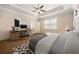 Bedroom with tray ceilings, hardwood floors, a ceiling fan, a desk and a comfortable bed at 2020 Rivermont Way, Roswell, GA 30076