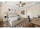 Bedroom with hardwood floors, a ceiling fan, a desk, a bed with gray bedding and abstract art at 2020 Rivermont Way, Roswell, GA 30076
