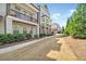Landscaped front of townhomes featuring sidewalks and covered patios for outdoor living at 2020 Rivermont Way, Roswell, GA 30076
