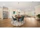 An open-concept living room and dining area with hardwood floors and stainless steel refrigerator at 2020 Rivermont Way, Roswell, GA 30076