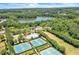 Aerial view showcasing tennis courts and community pool next to a lake surrounded by lush green trees at 429 Argonne Ter, Canton, GA 30115