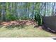 Backyard features sloped landscape with trees, grass and fenced perimeter at 1600 Ruskin Way, Marietta, GA 30062