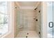 Modern bathroom shower featuring glass door, window, bench, and neutral tile at 1600 Ruskin Way, Marietta, GA 30062