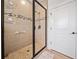 Modern bathroom featuring a glass enclosed shower with decorative tile and pebbled floor and a white door at 2442 Lower Union Hill Rd, Canton, GA 30115
