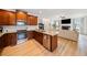 Open concept kitchen with stainless appliances, wood cabinets, and views to the living room at 2442 Lower Union Hill Rd, Canton, GA 30115