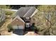 Aerial view of a two-story brick home, with a two-car garage, surrounded by mature trees and landscaping at 2688 Autumn Ridge Ln, Lawrenceville, GA 30044