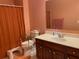 Cozy bathroom featuring a toilet with grab bars, vanity, and shower with peach fixtures at 2688 Autumn Ridge Ln, Lawrenceville, GA 30044