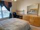 Bright bedroom featuring a mirrored dresser, side desk, and a comfortable bed with blue accents at 2688 Autumn Ridge Ln, Lawrenceville, GA 30044