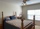 Bright bedroom featuring a traditional four-poster bed, ceiling fan, and natural light from the window at 2688 Autumn Ridge Ln, Lawrenceville, GA 30044