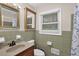Bathroom featuring green tiling, dual mirrors, and a shower with blue patterned curtain at 3441 Palace Ct, Tucker, GA 30084