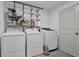 Laundry room features modern washer and dryer units, wire rack storage, and white trim at 3441 Palace Ct, Tucker, GA 30084