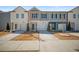Modern townhome exterior featuring a mix of neutral siding and a concrete driveway at 7083 Gladstone Cir, Stonecrest, GA 30038