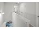 Bright hallway with white walls, connecting various rooms and featuring a view of the living area below at 7083 Gladstone Cir, Stonecrest, GA 30038