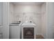 Compact laundry room featuring a modern washer and dryer set with white cabinets above at 7083 Gladstone Cir, Stonecrest, GA 30038