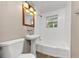 A charming bathroom with a pedestal sink, bathtub, and updated fixtures at 1679 Sw Lisbon Sw Dr, Atlanta, GA 30310