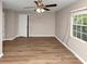An empty bedroom featuring wood-look floors, ceiling fan, and a large window at 1679 Sw Lisbon Sw Dr, Atlanta, GA 30310