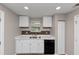 Efficient kitchen featuring white cabinetry, stone-look backsplash, stainless steel sink, and laminate countertops at 1679 Sw Lisbon Sw Dr, Atlanta, GA 30310