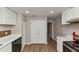 Updated kitchen features white countertops and cabinets, stainless steel appliances, and laminate flooring at 1679 Sw Lisbon Sw Dr, Atlanta, GA 30310