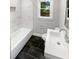 Modern bathroom featuring a black tiled floor, white fixtures and tiled walls at 1886 Hazelwood Se Dr, Marietta, GA 30067