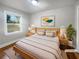 Bright, staged bedroom with a window, natural wood furniture and neutral bedding at 1886 Hazelwood Se Dr, Marietta, GA 30067