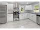 Well-lit kitchen with white cabinets, granite countertops, stainless steel appliances, and tile flooring at 1886 Hazelwood Se Dr, Marietta, GA 30067