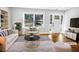 Bright, staged living room with large window, hardwood floors, white sofa and chair, and built in bookshelf at 1886 Hazelwood Se Dr, Marietta, GA 30067