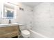 Modern bathroom featuring marble tiling, a vanity with a lighted mirror, and a shower-tub combo at 2965 Pharr Court South Nw # 503, Atlanta, GA 30305