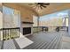 Covered deck with outdoor fireplace, ceiling fan, and wooded view at 3515 Montebello Pkwy, Cumming, GA 30028