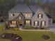 Stunning two-story home featuring stone accents, a well-manicured lawn, and beautiful landscaping at 3515 Montebello Pkwy, Cumming, GA 30028