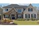 Charming two-story home with brick and stone accents, black shutters, manicured lawn and landscape in the front yard at 3515 Montebello Pkwy, Cumming, GA 30028