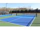 These blue and green pickleball courts are lit, fenced, with trees in the background, and benches available at 3515 Montebello Pkwy, Cumming, GA 30028
