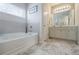 Well-lit bathroom with soaking tub, gray tile flooring, and white vanity with great natural light at 4870 Odum View Ln, Cumming, GA 30040
